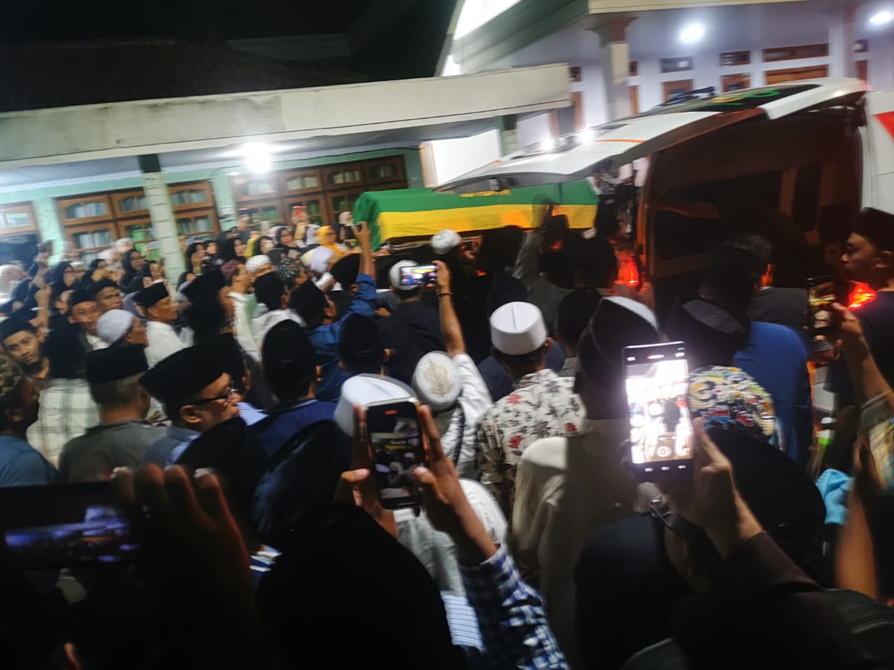 Pihak Keluarga Dan Masyarakat Menyambut Kedatangan Jenazah Hj. Mimin Hariyati Slamet Junaidi Di Kelurahan Karang Dalem, Sampang Pada Selasa Malam (28/5).