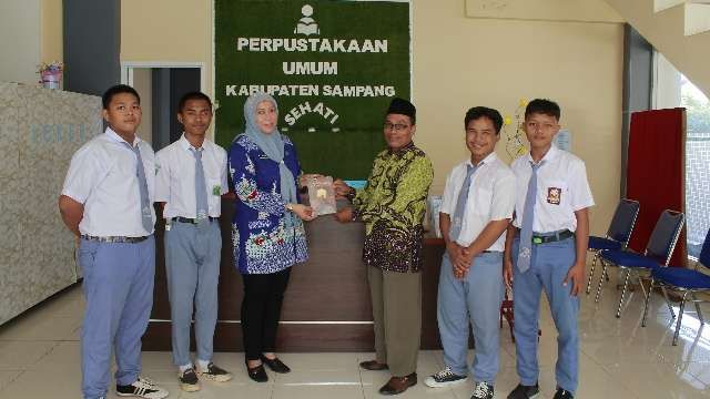Hibah Buku dari SMA Darussyahid Tambah Koleksi Perpusda Sampang 1 Siswa SMA Darussyahid saat menyerahkan buku karya tulis (Foto: Dispusip Sampang)